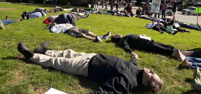People lying on the ground pretending to be dead.
